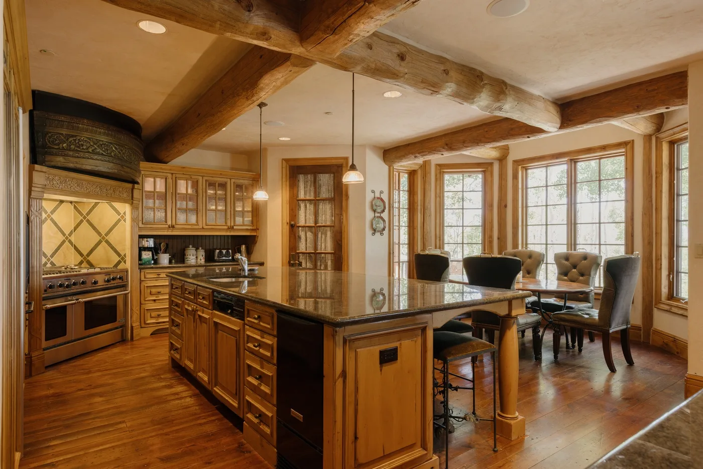 Una cocina amplia con una isla central y un comedor junto a grandes ventanas.
