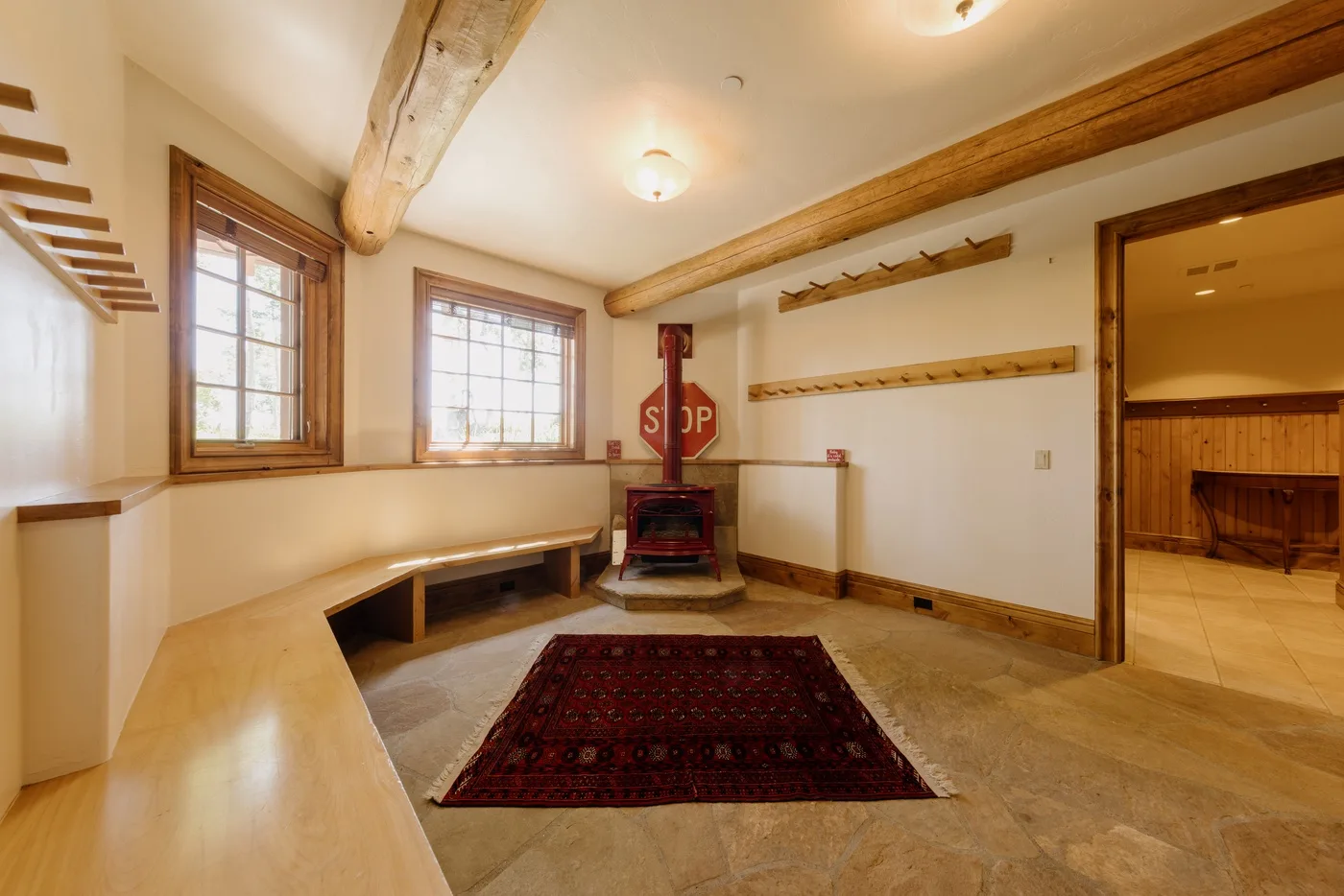 Una cálida sala interior con estufa de leña, ventanas y asientos integrados.