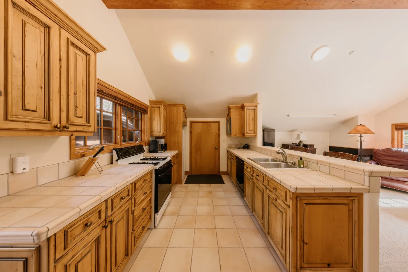 Una cocina amplia con gabinetes de madera, encimeras de azulejos e isla central.
