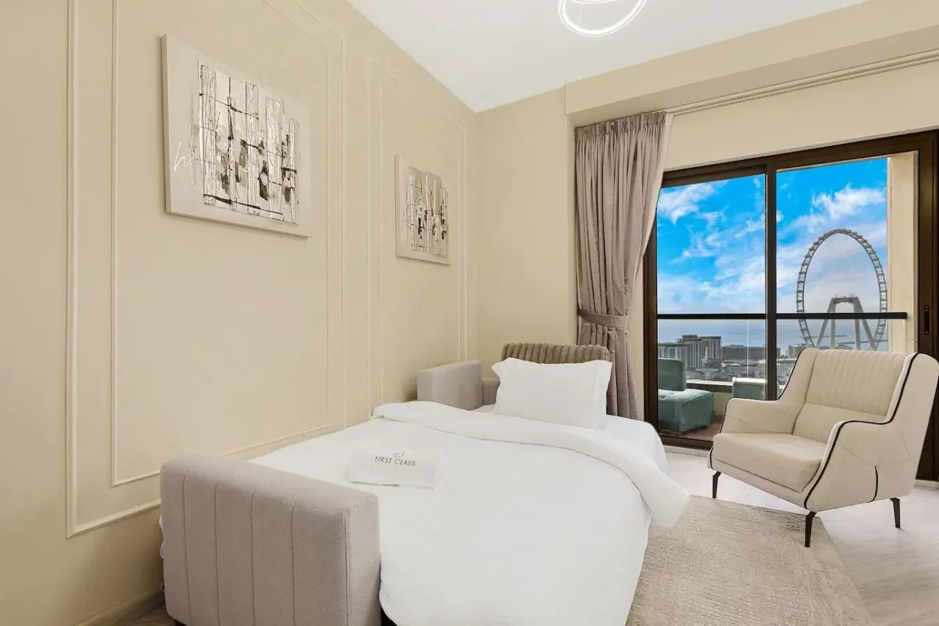 A bright bedroom with a neatly made bed and an armchair beside a large window.