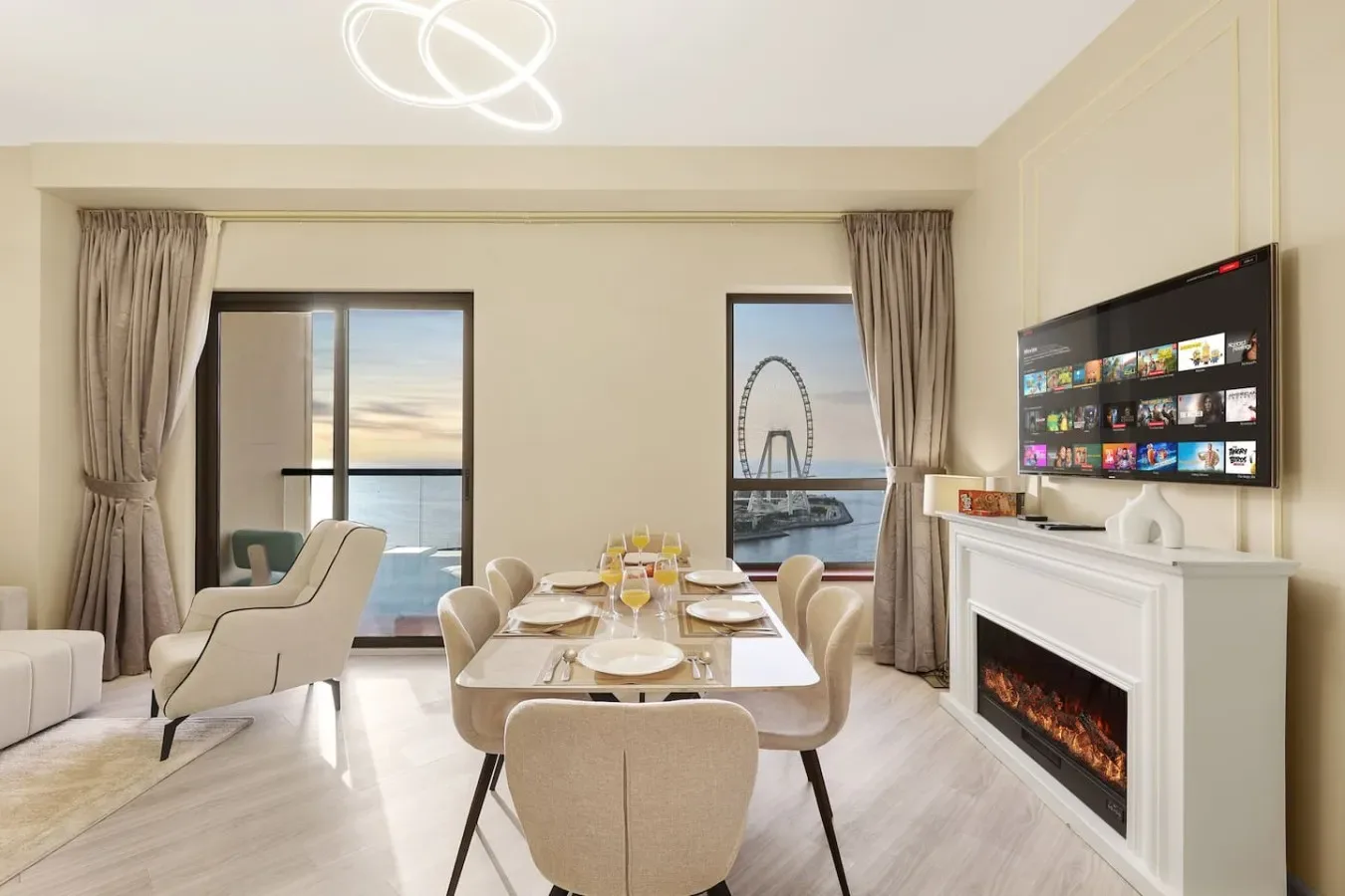 A bright dining and living area with a table, seating, and a fireplace.