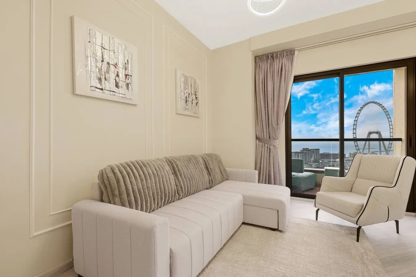 A bright living room with upholstered seating and a large window overlooking the city.
