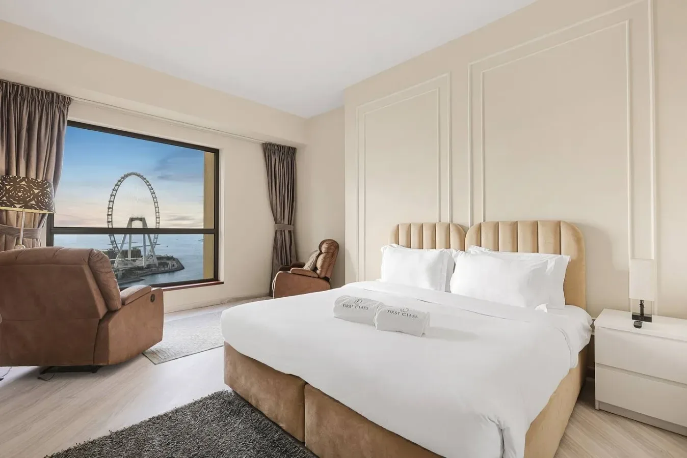 A bright bedroom with a neatly made bed beside a large window.