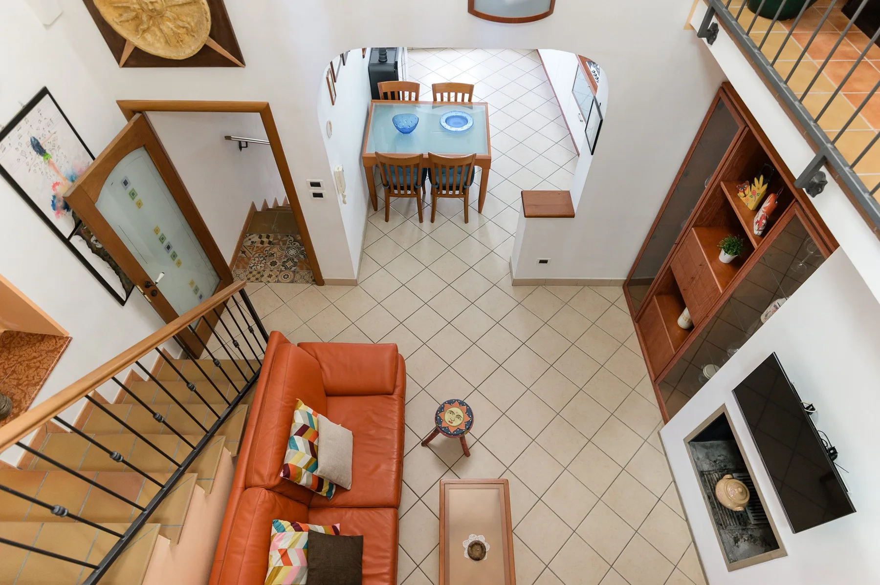 Una luminosa sala de estar con mesa de comedor, asientos y suelo de baldosas.