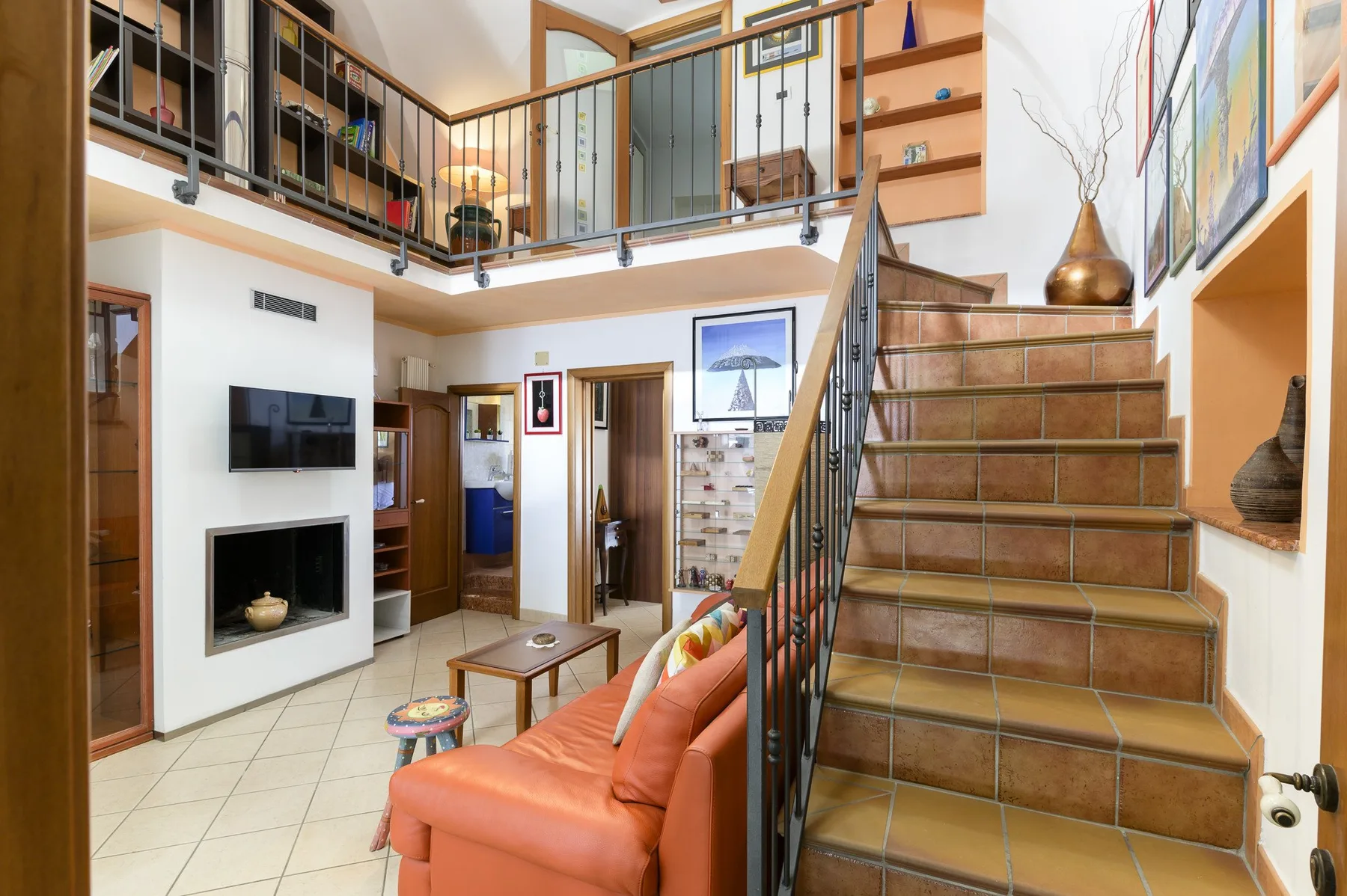 Una sala luminosa con escaleras de baldosas y una barandilla de entrepiso.