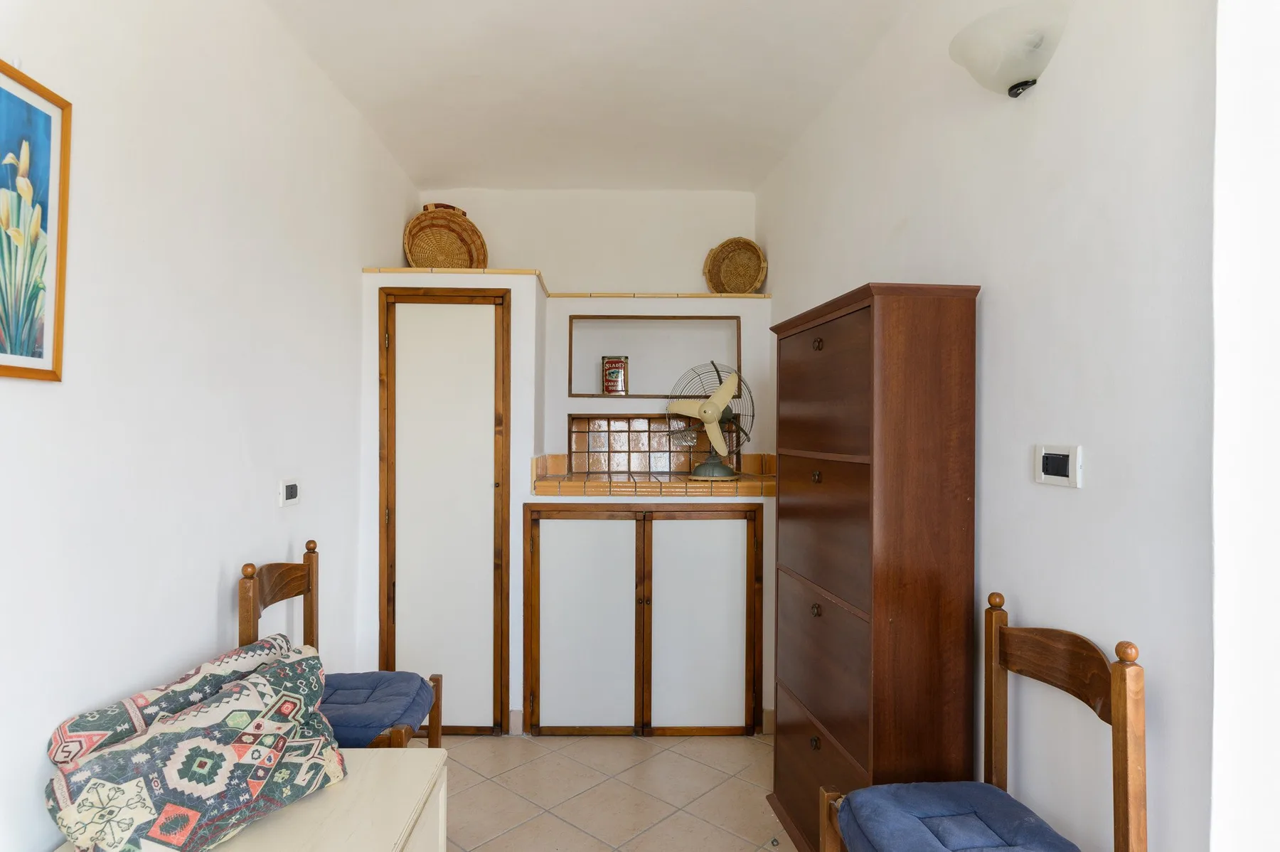 Una habitación luminosa con asientos de madera y un armario empotrado en la pared del fondo.