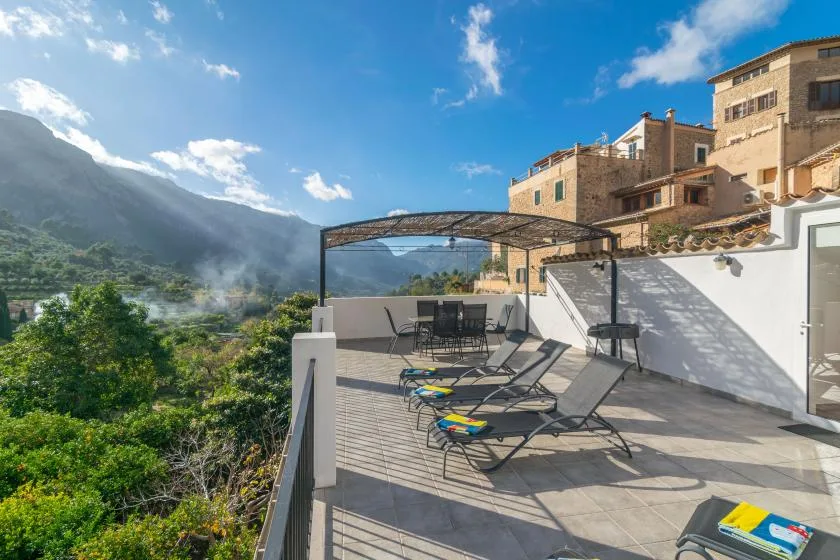 Una terraza en la azotea con asientos mira hacia un valle montañoso y verde.