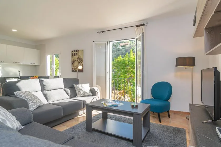 Una sala luminosa con asientos grises, una mesa de centro y una silla azul.