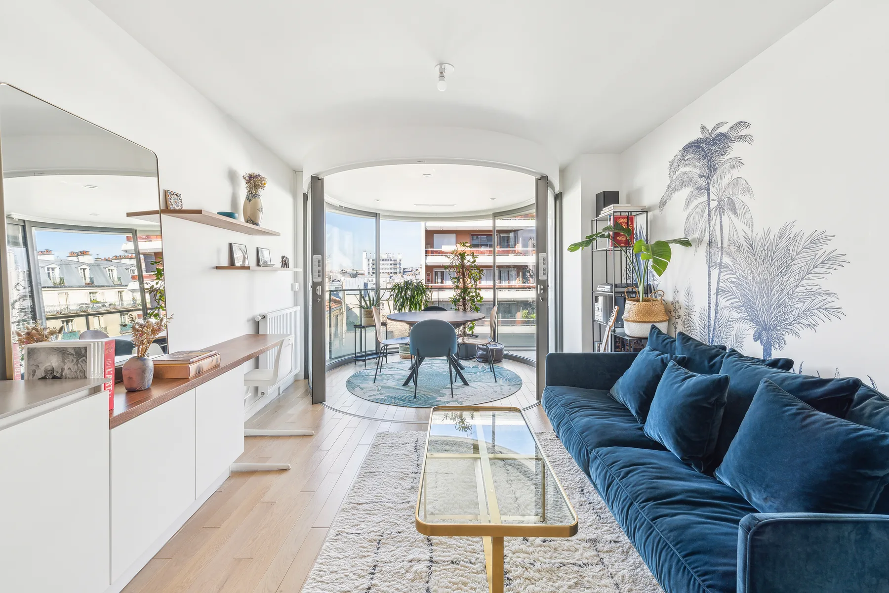 Una sala luminosa con asientos azules y una mesa de centro de vidrio.