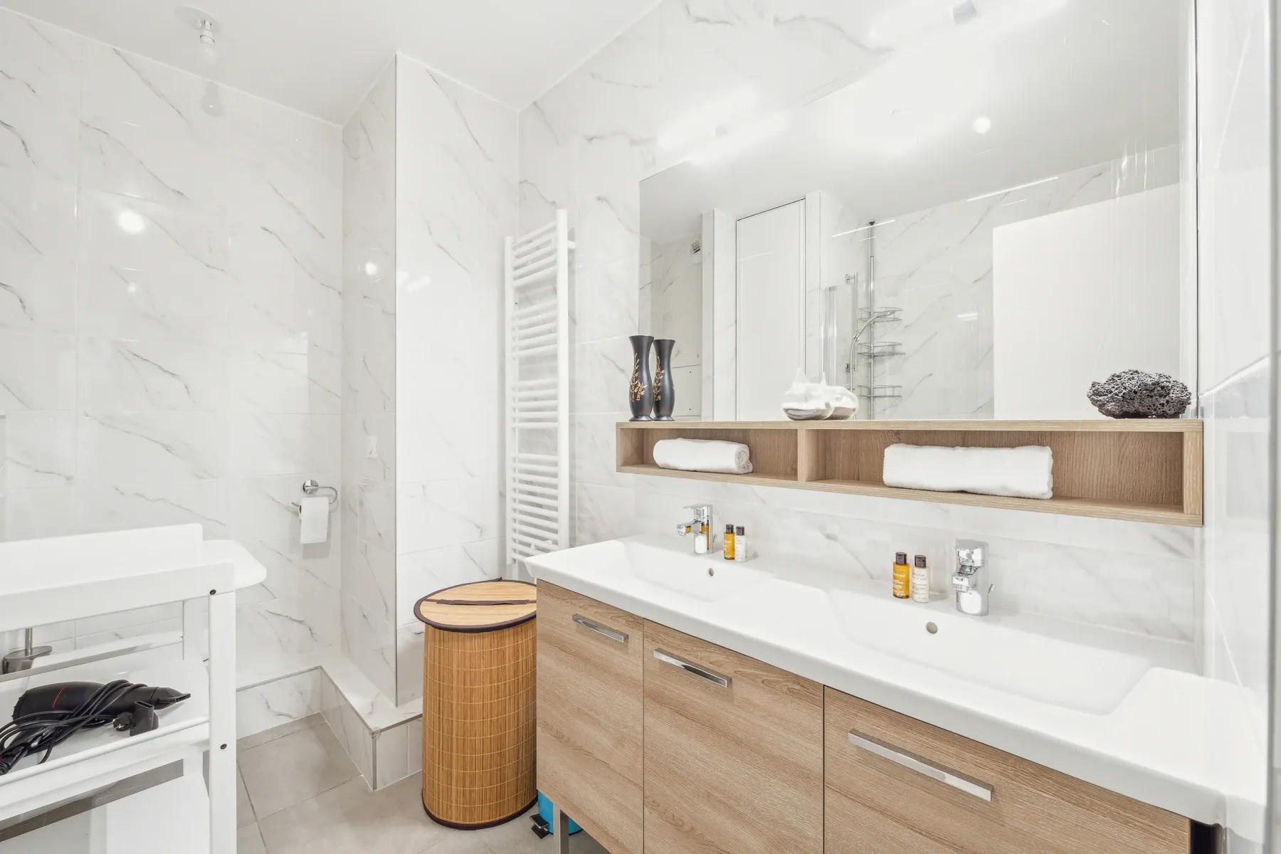 Un baño luminoso con un lavabo largo y un espejo amplio.