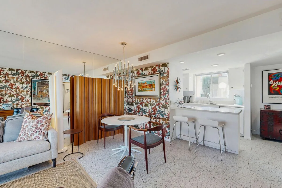 An open living and dining area with a small kitchen counter and seating.