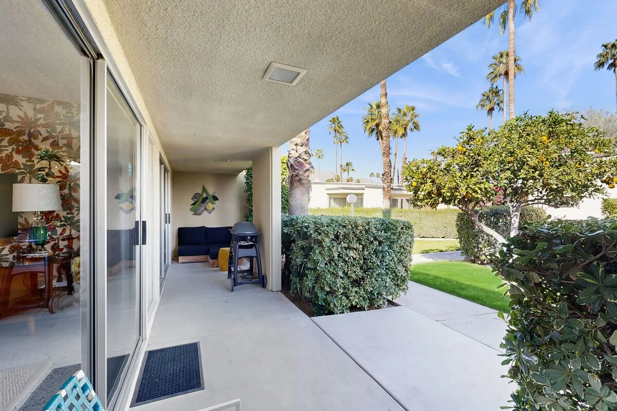 A covered patio with sliding glass doors opens onto a landscaped garden.