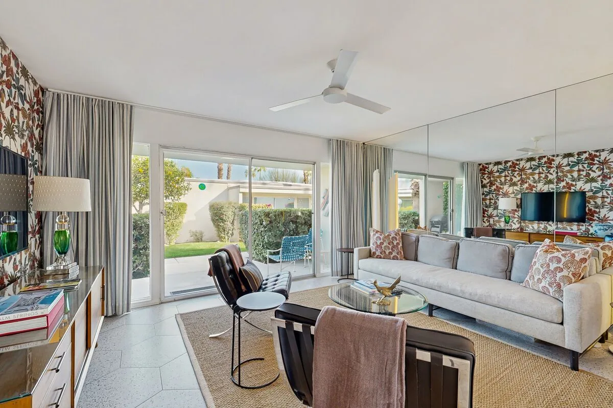 A bright living room with seating around a coffee table and sliding glass doors.