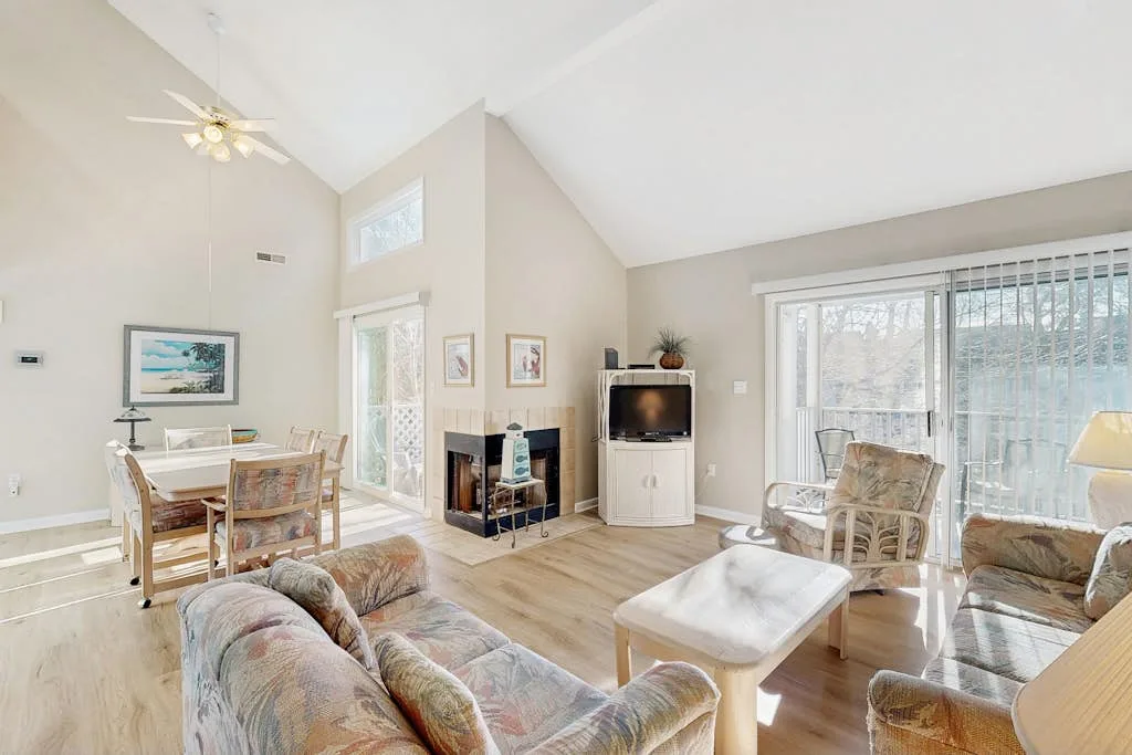 A bright living room with seating, a coffee table, and large glass doors.