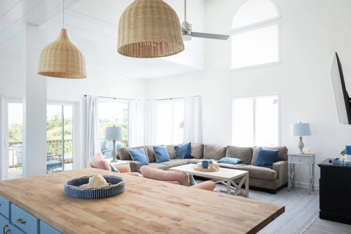 Una sala luminosa con asientos alrededor de una mesa de centro y grandes ventanas.