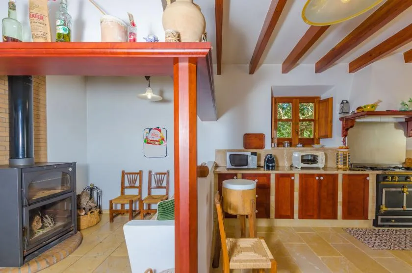 Cocina y comedor rústicos con vigas de madera en el techo y una chimenea.