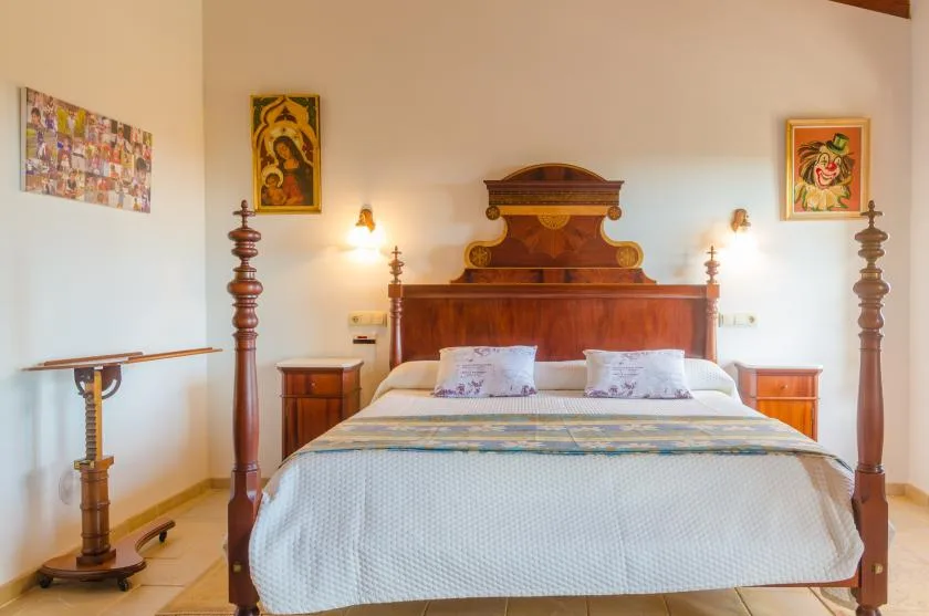 Un dormitorio con una cama grande de madera y cuadros en las paredes.