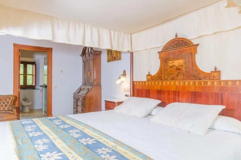 Un dormitorio con una cama y un cabecero de madera ornamentado.