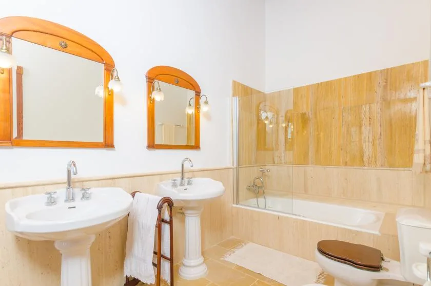 Un baño con dos lavabos, espejos y una bañera.