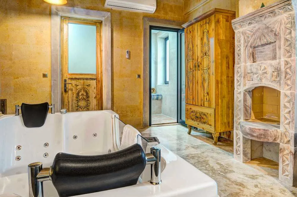 Detalle del jacuzzi y la chimenea de piedra de la Suite Superior