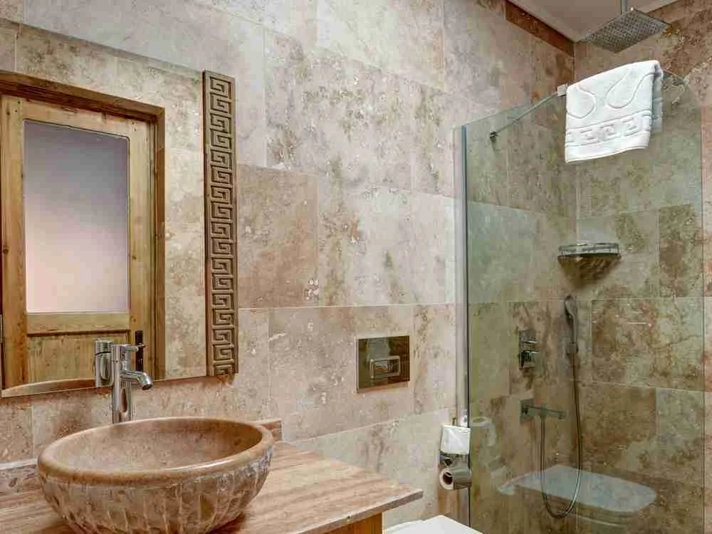 Baño de la habitación con ducha y lavabo de piedra