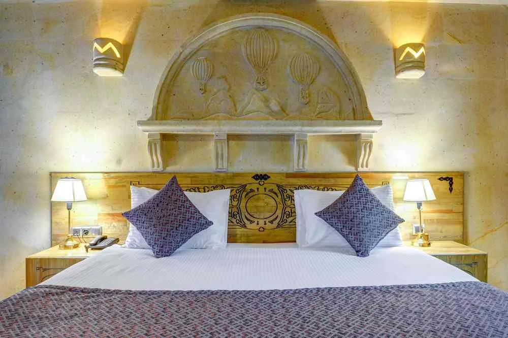 Cabecero de piedra tallada y cama de la suite Deluxe