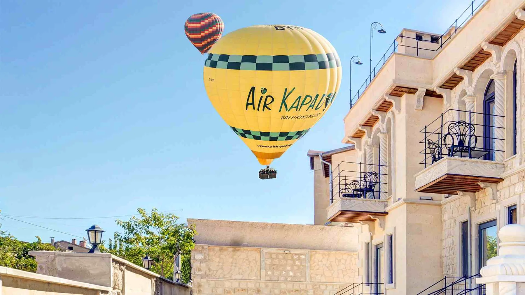 Stone hotel exterior with a hot-air balloon overhead