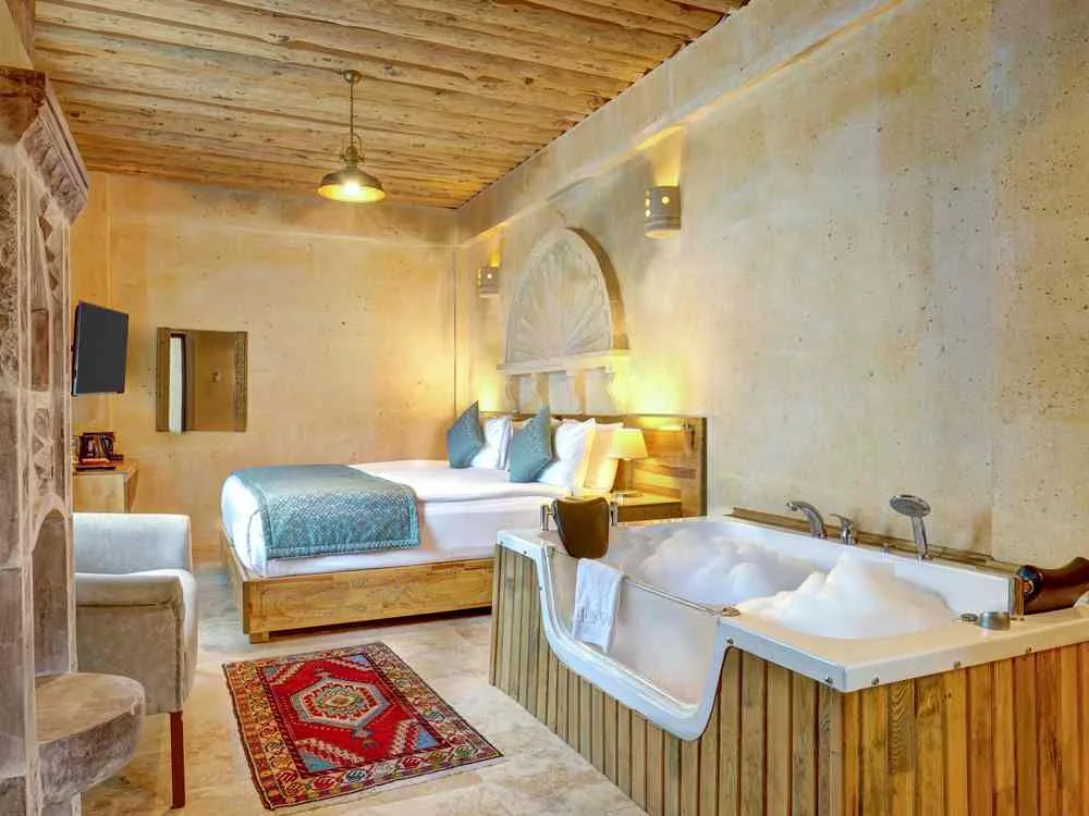 Interior de una suite con cama y jacuzzi