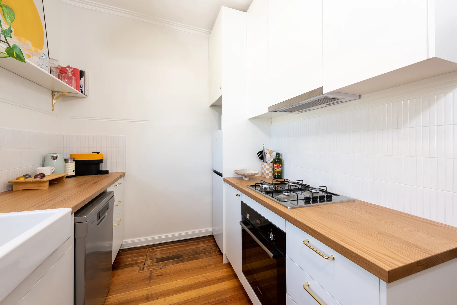 A bright kitchen with wood countertops and a gas cooktop.
