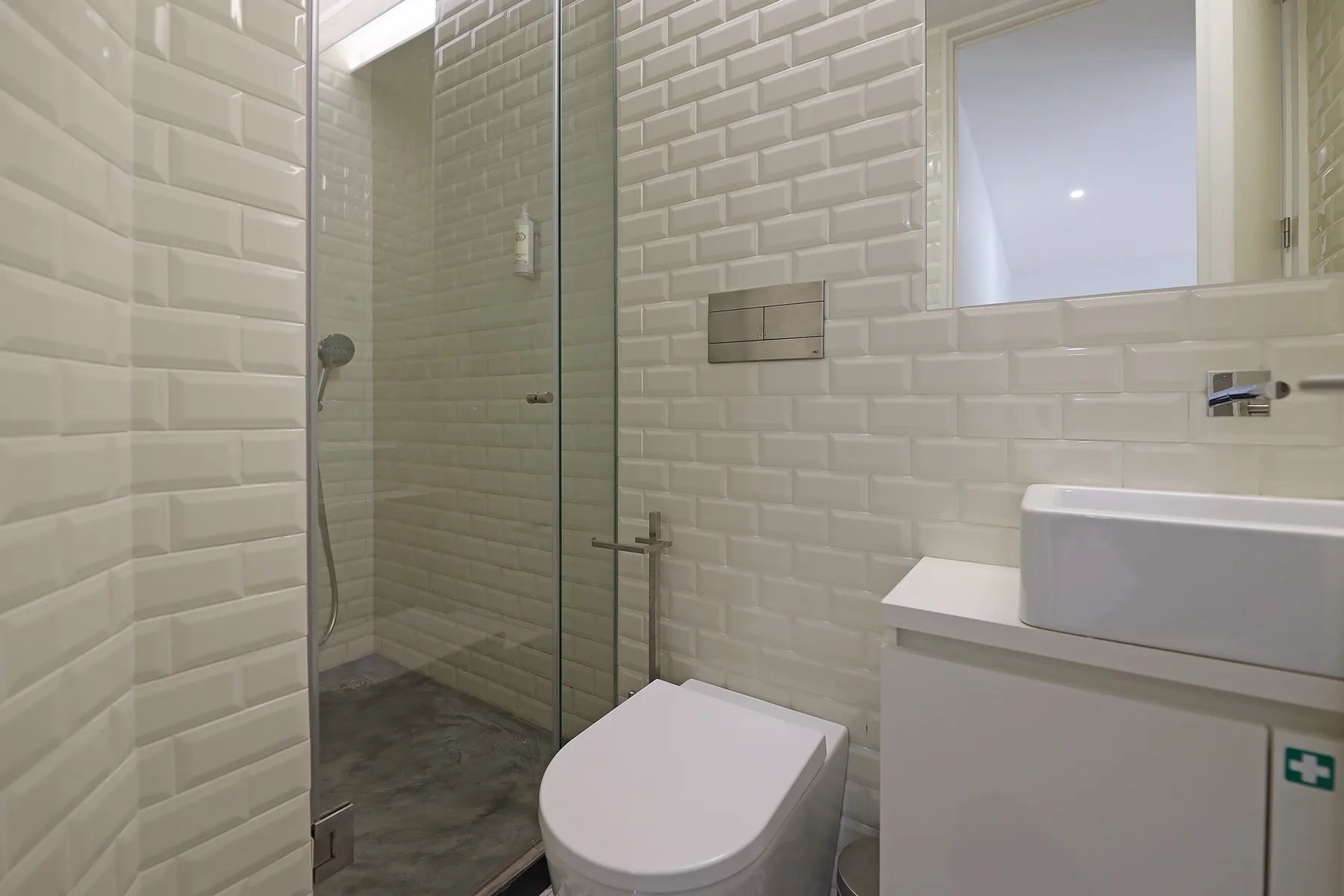 A tiled bathroom with a shower, toilet, and sink.