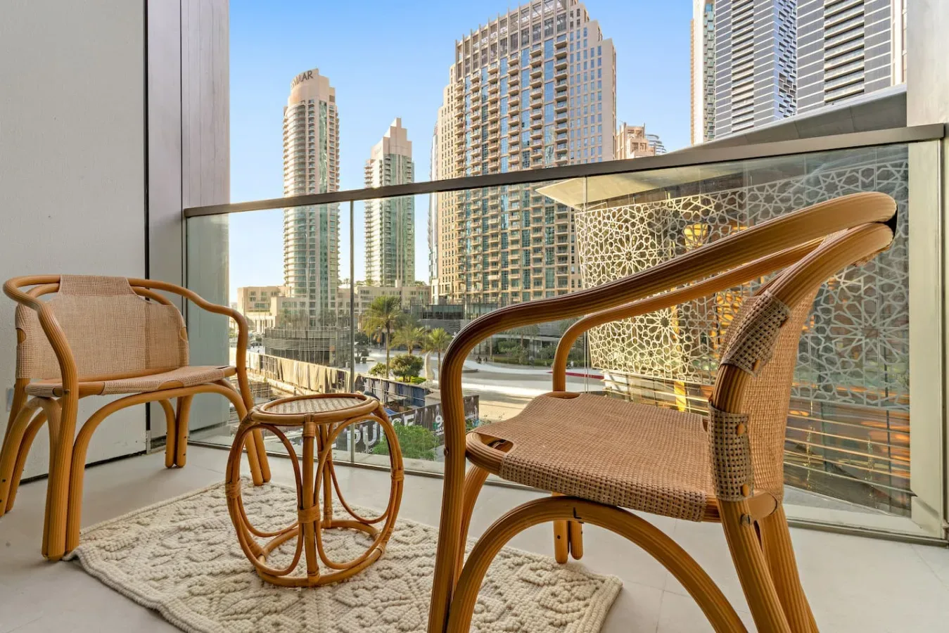 A balcony seating area overlooks nearby high-rise buildings.