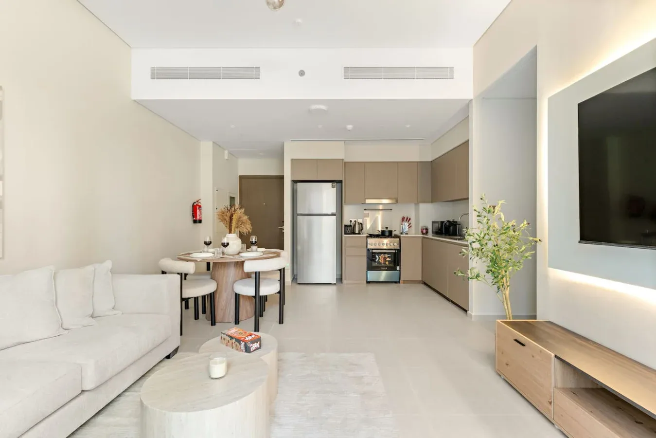 Una luminosa sala de estar y cocina de concepto abierto con sofá y mesa de comedor.