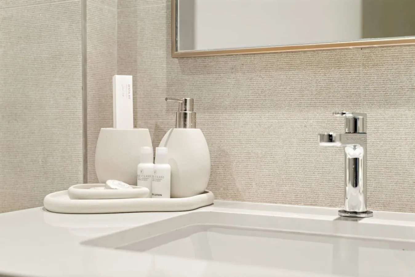Un lavabo de baño con grifo cromado y artículos de aseo sobre la encimera.