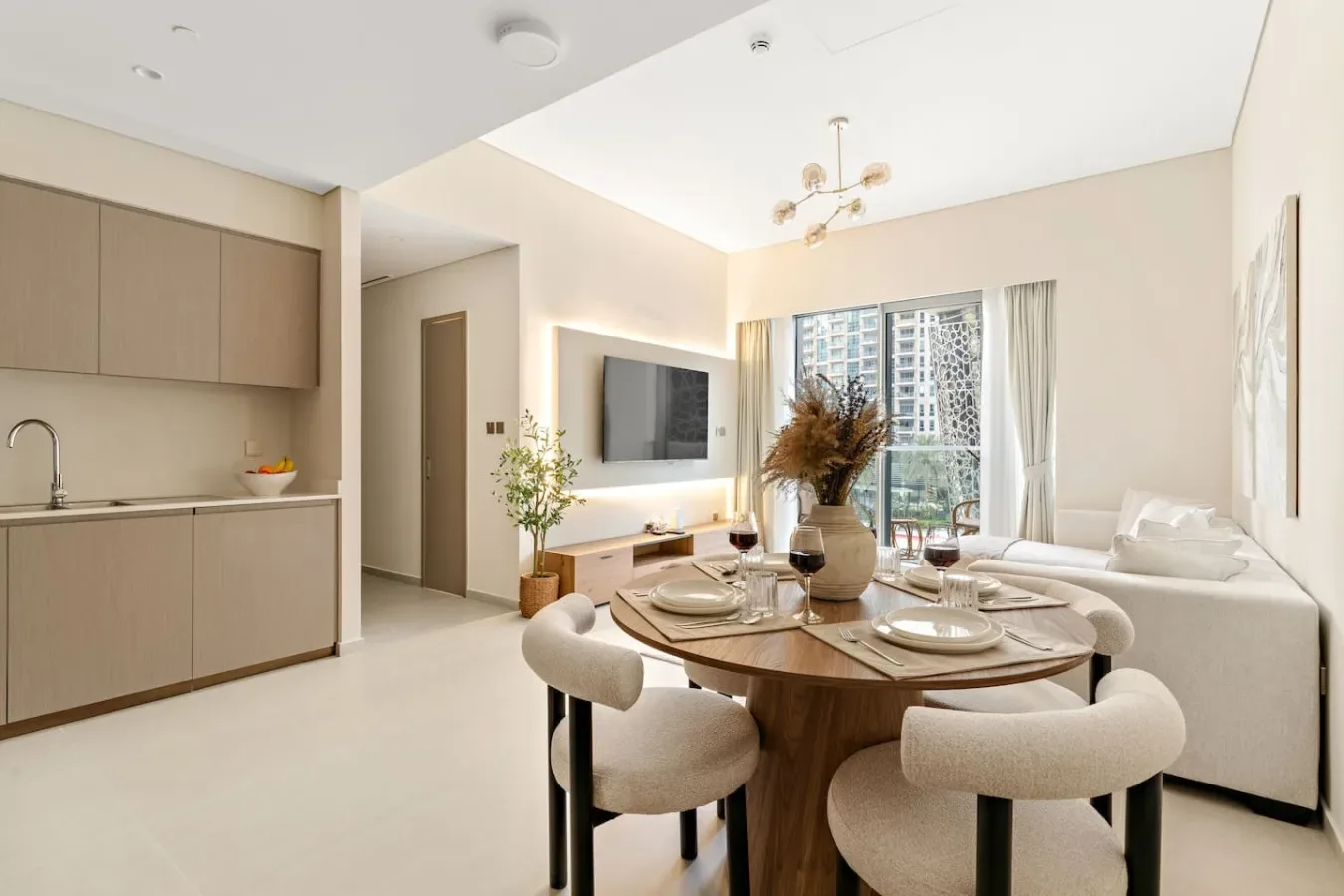 A bright open-plan living area with a dining table beside the kitchen and seating.