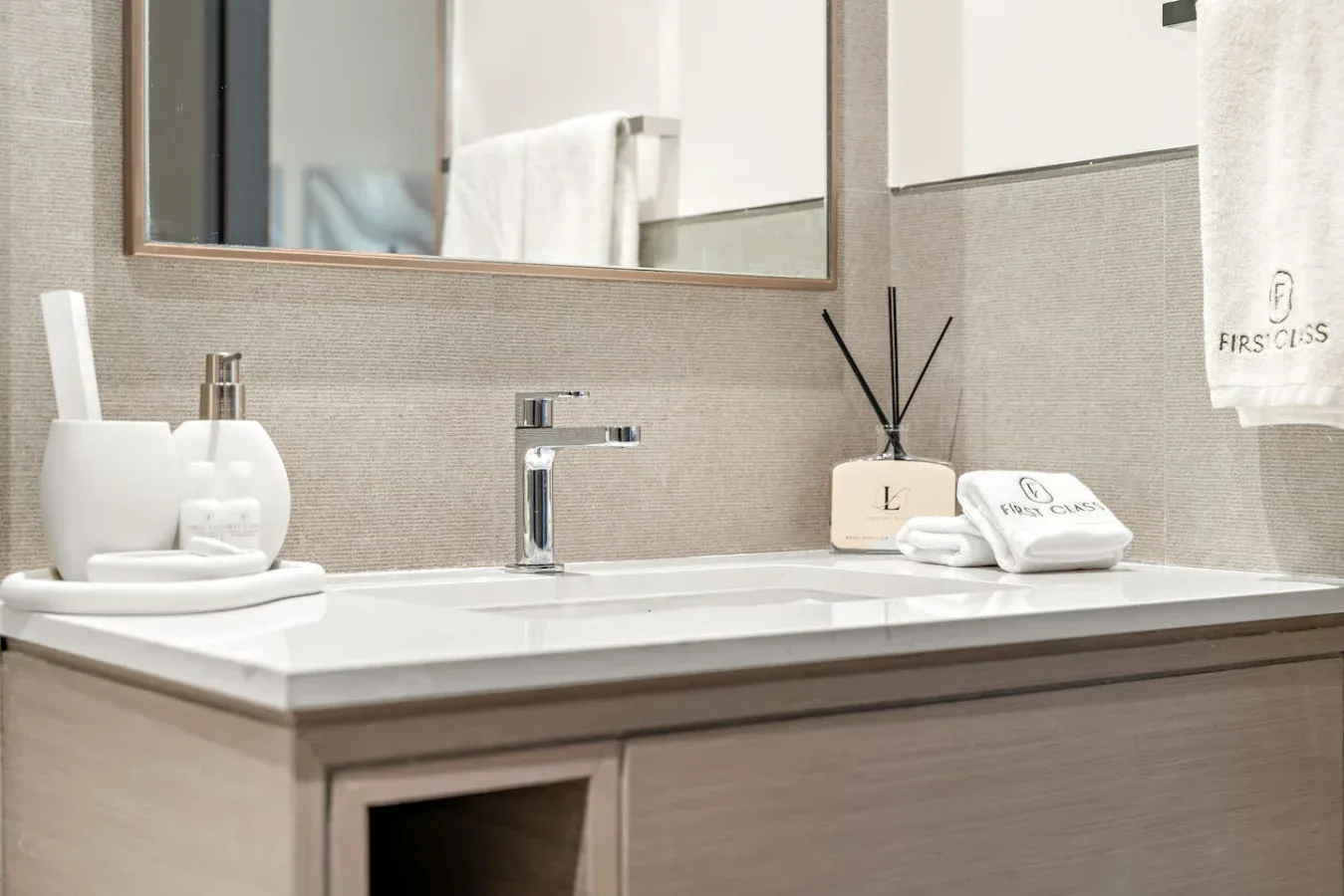 Un lavabo de baño con espejo y artículos de aseo ordenados.