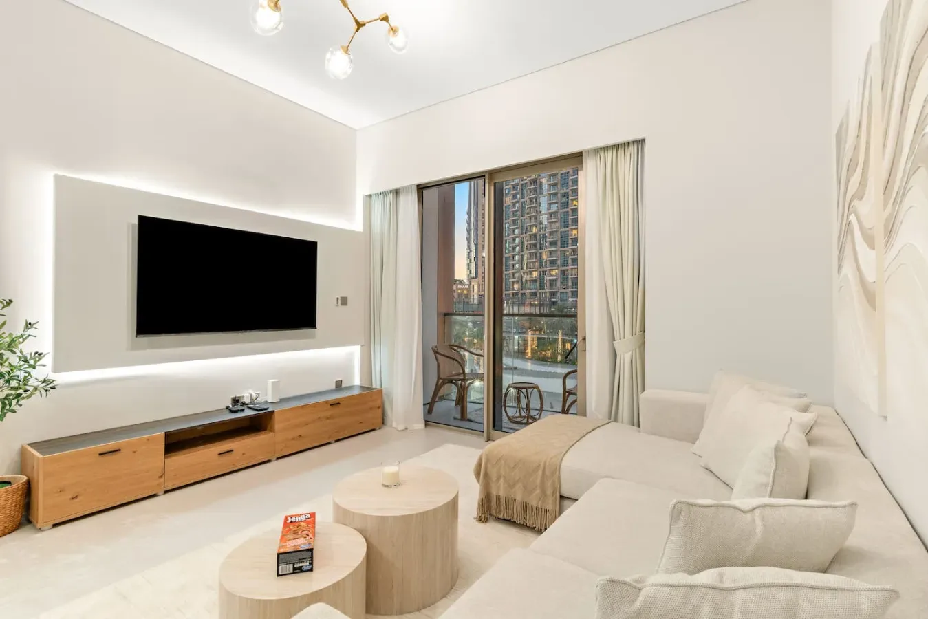 Una sala luminosa con televisor, asientos y una ventana amplia.