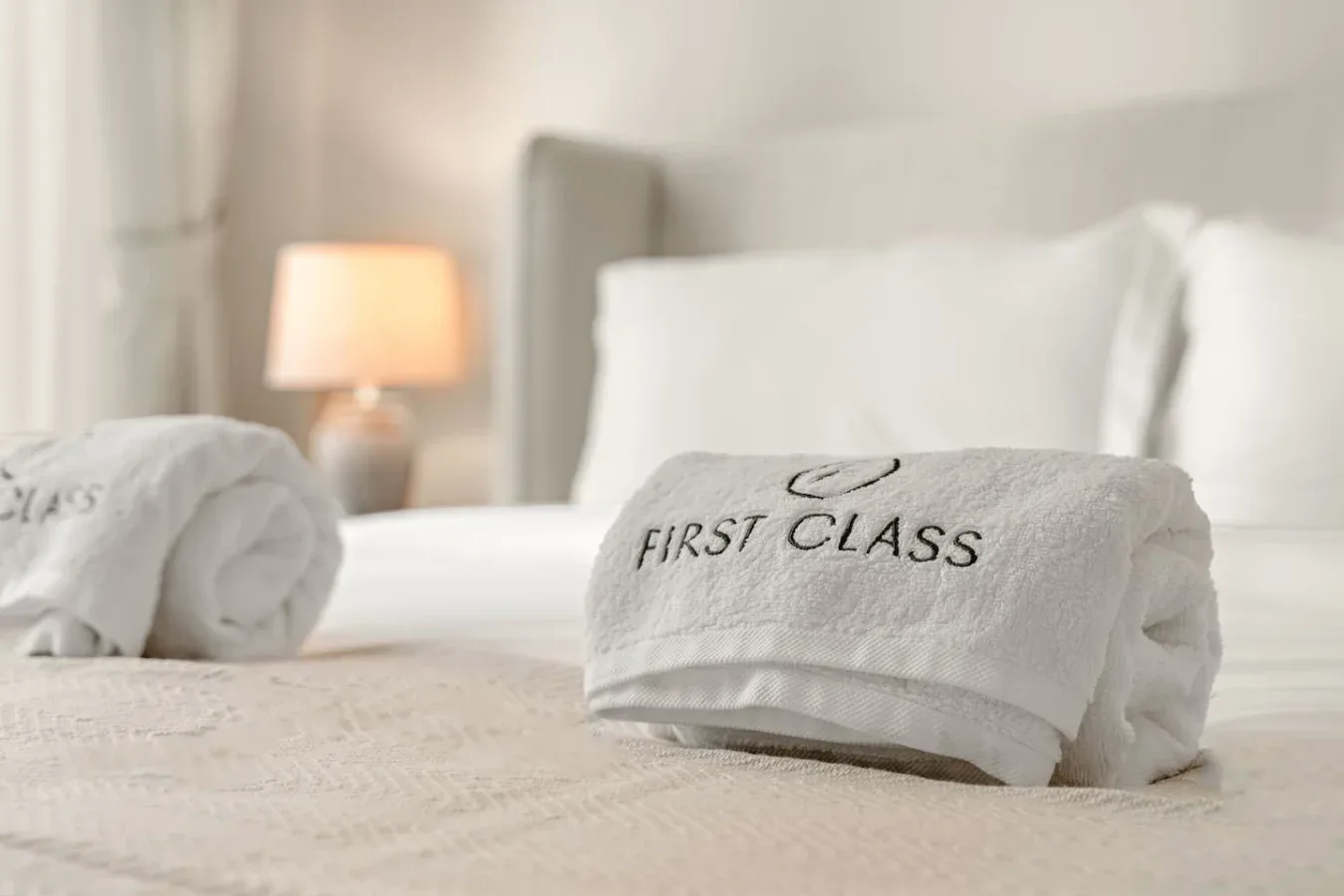 Un dormitorio con toallas blancas dobladas cuidadosamente sobre la cama.