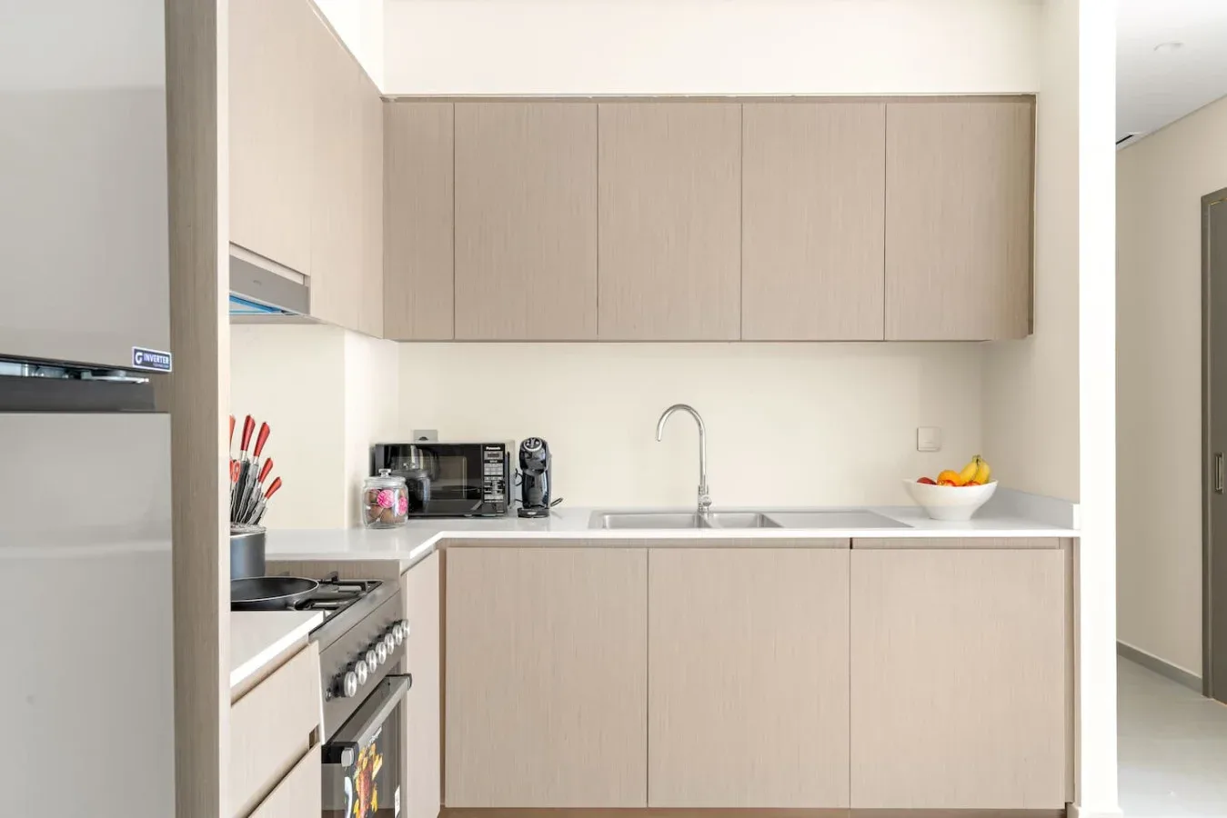 Una cocina moderna con gabinetes claros, una encimera y un fregadero.