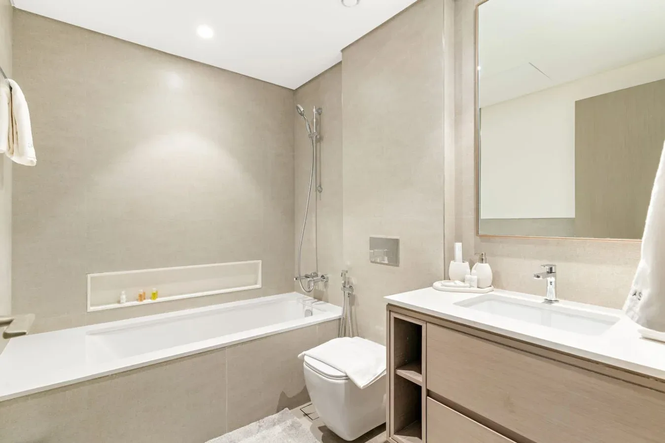 Un baño luminoso con bañera, ducha, inodoro y lavabo.