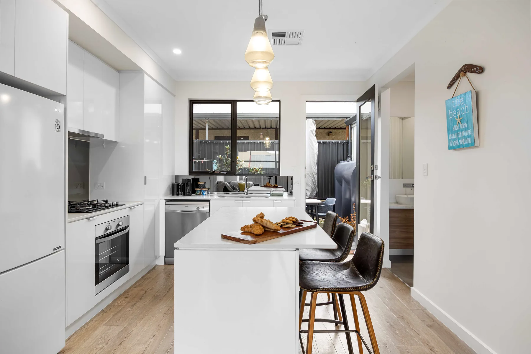 Una cocina moderna y luminosa con una isla central y asientos de bar.