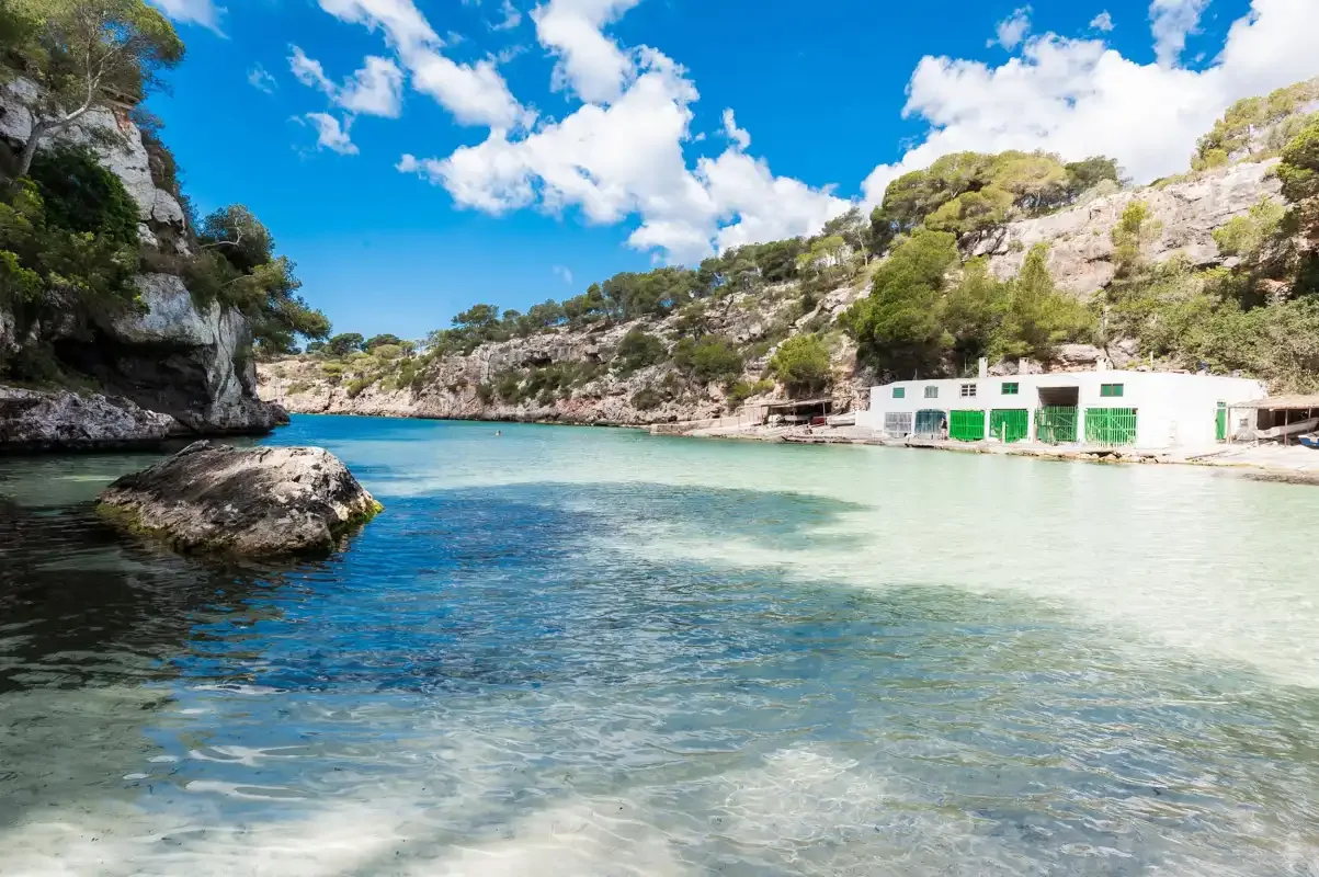 A sheltered cove with clear water and rocky cliffs along the shore.