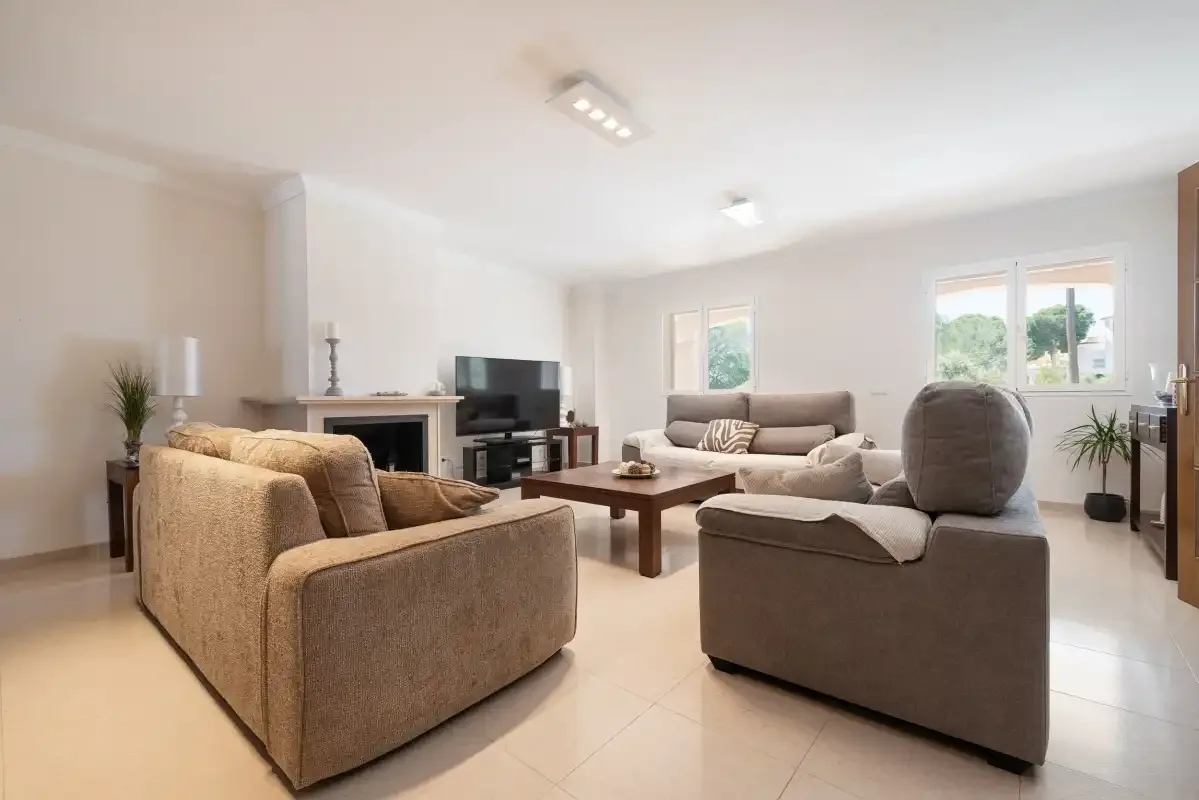 A bright living room with seating arranged around a low coffee table.
