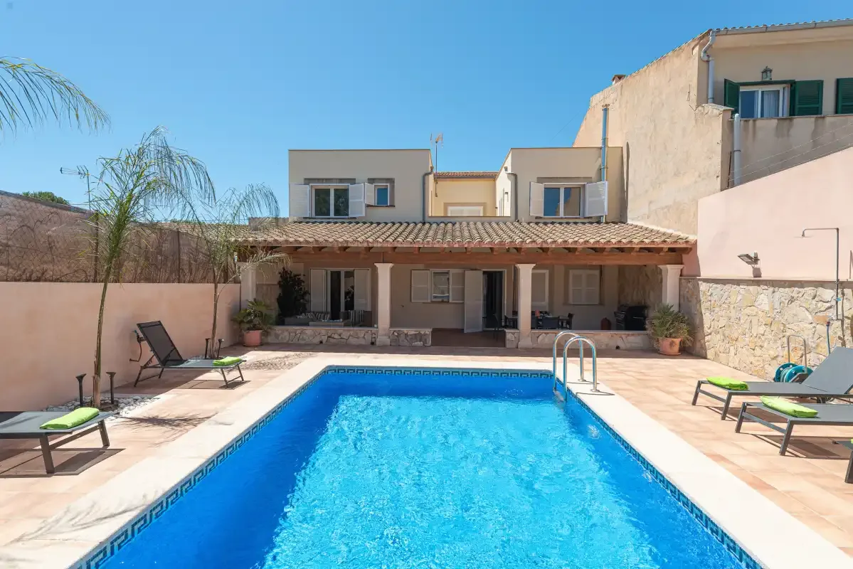 A courtyard swimming pool faces a covered patio with outdoor seating.