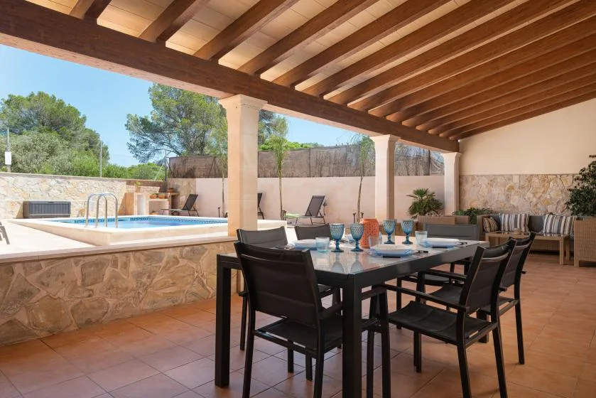 Covered outdoor dining area beside a swimming pool.