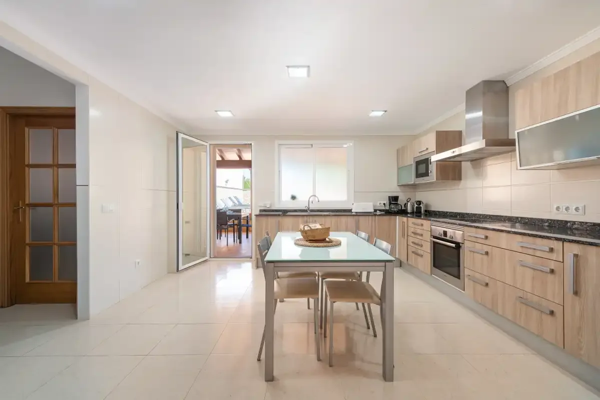 A bright kitchen with wood cabinetry and a central dining table.