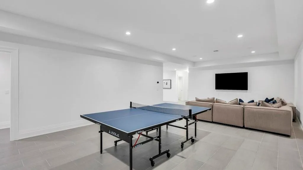 Una sala luminosa cuenta con una mesa de ping-pong y una zona de asientos.