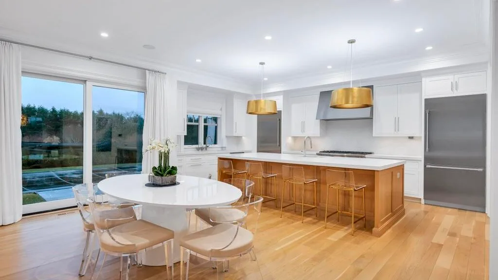 Cocina y comedor diáfanos y luminosos, con una isla central y grandes ventanales.