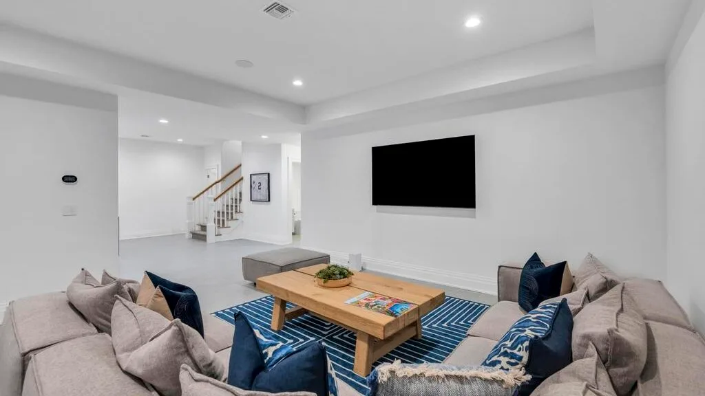 Una sala luminosa con asientos alrededor de una mesa de centro de madera y un televisor.