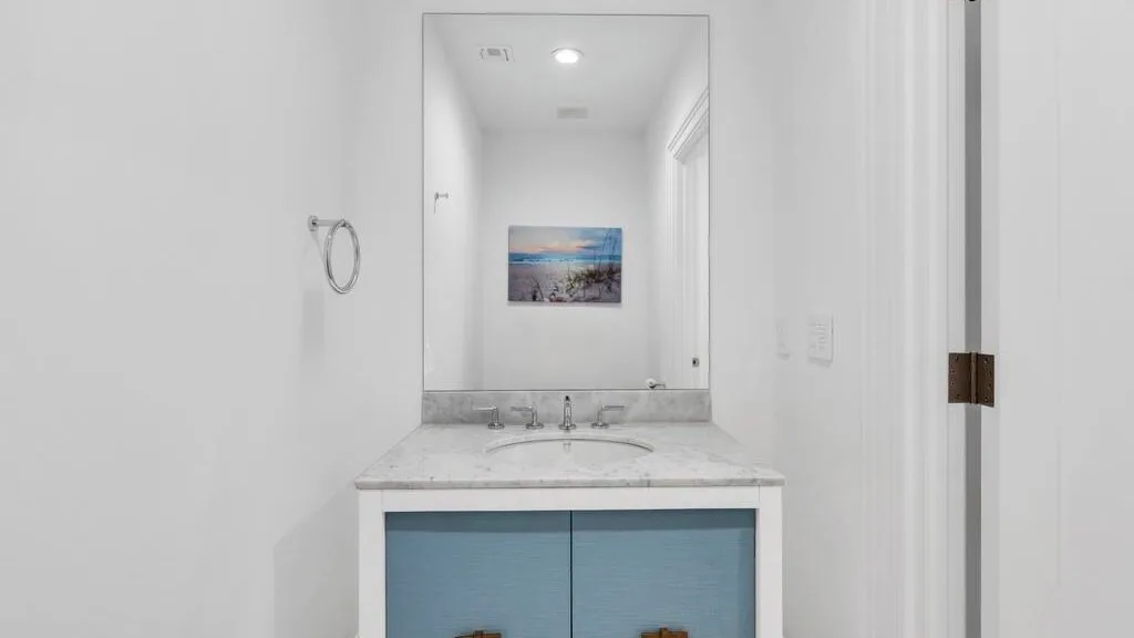 Un baño luminoso con un amplio tocador bajo un espejo.