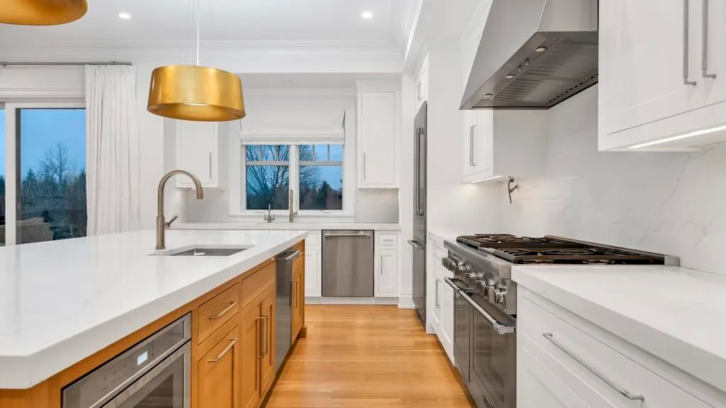 Una cocina moderna y luminosa con una isla central y electrodomésticos de acero inoxidable.